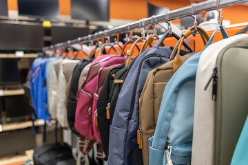 A rack of backpacks and a few other items hang on a rack