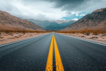 Fototapeta premium A road leading into the desert with mountains in the background
