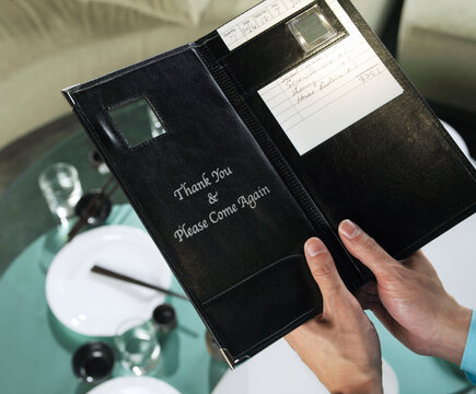 Close-up of Man's Hands Holding Restaurant Bill