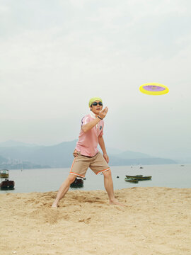 Man Playing Frisbee on the Beach