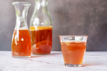 A glass of fermented probiotic tea drink kombucha on marble table background.