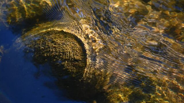 Clear stream running through stone boulders.