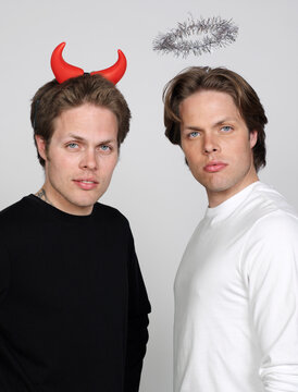 Portrait of Twin Brothers Dressed Like Devil and Angel