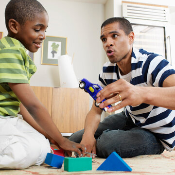 Father and Son Playing with Toys