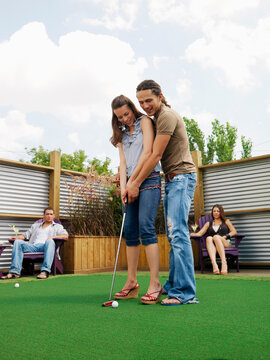 Couple Playing Miniature Golf