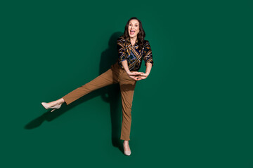 Photo of positive lovely senior lady wear trendy clothes dance good mood isolated on green color background