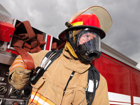 Fireman Pulling Fire Hose from Fire Truck