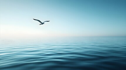 Fototapeta premium A single bird gracefully soaring over a calm serene ocean seascape with a clear blue sky providing ample copy space for text or graphic overlays