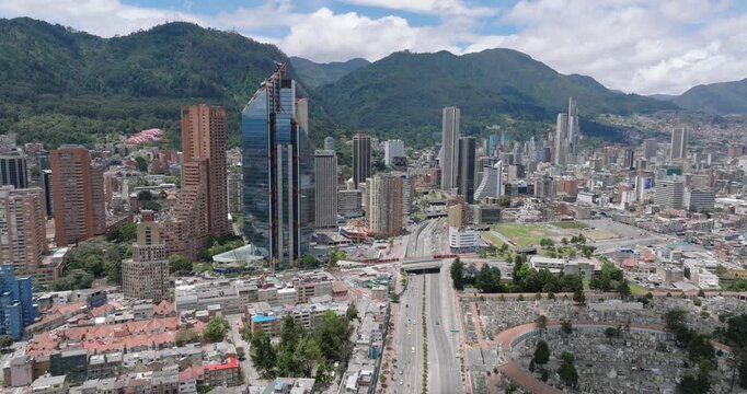 Static drone shot overlooking Bogota city center and mountains, on a sunny day, over the 26th avenue