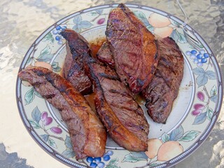Picanha, or top sirloin cap, steaks on a charcoal grill