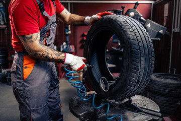 Tire repairman using tools to patch a flat damaged tire.