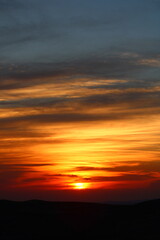 The sun setting behind the clouds. Orange sky. Amazing sunset