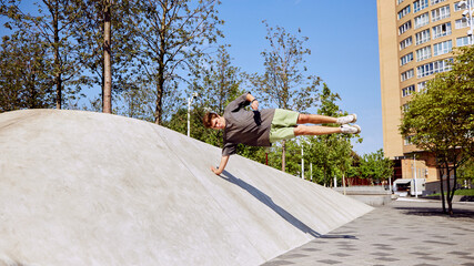 Defying gravity, young athletic man balancing sideways on one hand, demonstrating strength required...
