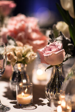 Close-up of vases with roses on table with candlelit votive holder at reception, Canada