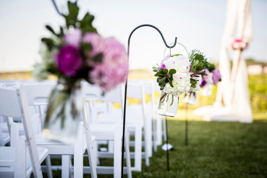 Flowers Hanging at End of Rows of Chairs at Wedding