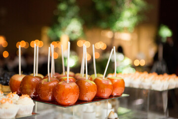 Close-up of dessert platters with glazed apples on sticks, at an event, Canada