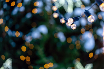 garland of light bulbs on defocused festive lights background, shallow depth of field, copy space