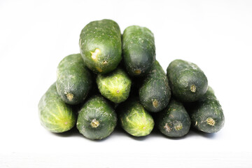 Pile of small cucumbers isolated on a white. Home garden vegetables. Fresh vegetables group. Size perfect for pickling. Fresh picked cucumber.