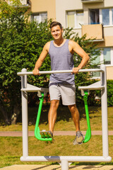 Man doing legs exercises in outdoor gym