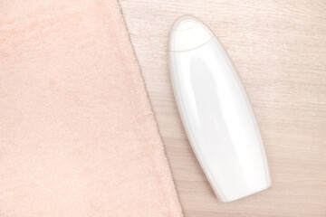 White plastic container on a wooden surface. There is a towel nearby.