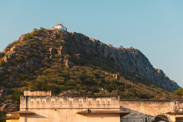 Walls of Alwar City Palace with Alwar Fort on the hilltop in the distance; Alwar, Rajasthan, India