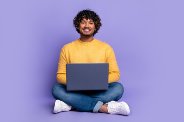 Photo of cheerful glad man wear trendy yellow clothes use gadget isolated on purple color background