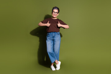 Full size photo of nice aged woman thumb up empty space wear t-shirt isolated on khaki color background