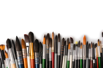 Mix of paint brushes in a row isolated on a white background.