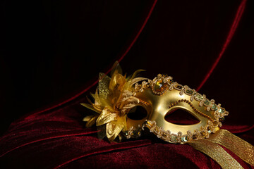 Beautiful golden carnival mask on red silk fabric