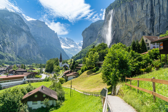 Summer landscape of famous alpine village Lauterbrunnen with famous church and Staubbach waterfall. Berner Oberland, Switzerland, Europe