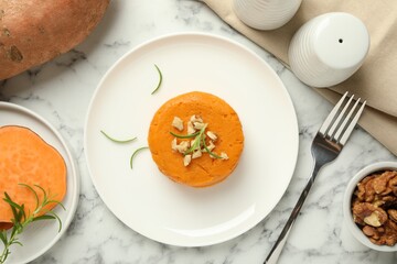 Tasty mashed sweet potato, rosemary and walnuts served on white marble table, flat lay