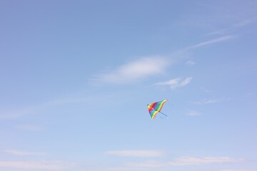 One colorful kite flying in blue sky