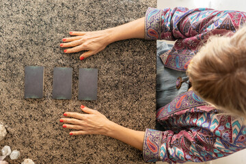 Top view of a tarot reader and three cards turned face down