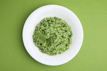 Delicious spinach risotto on light green background, top view