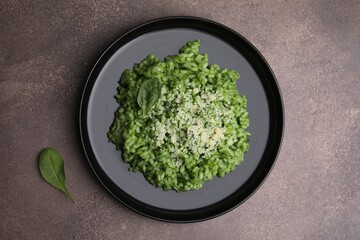 Delicious spinach risotto with parmesan cheese on grey table, top view