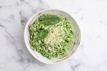 Tasty spinach risotto served on white marble table, top view