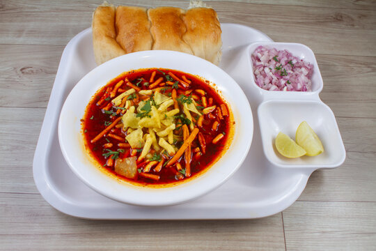 Indian cuisine food " Missal Pav " in a white plate on a table