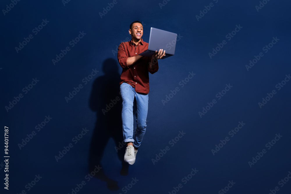 Poster Full length photo of attractive funny guy wear formal shirt jumping high typing emails modern gadget isolated blue color background