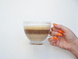 Cup of coffee in womans hand on white background