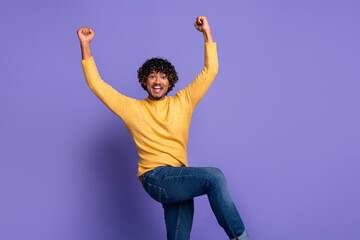 Photo of overjoyed glad man wear stylish yellow clothes hands fists yes isolated on violet color background