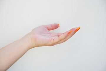 woman hand with orange nails on white background