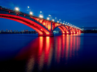 A bridge over a wide river with night illumination.