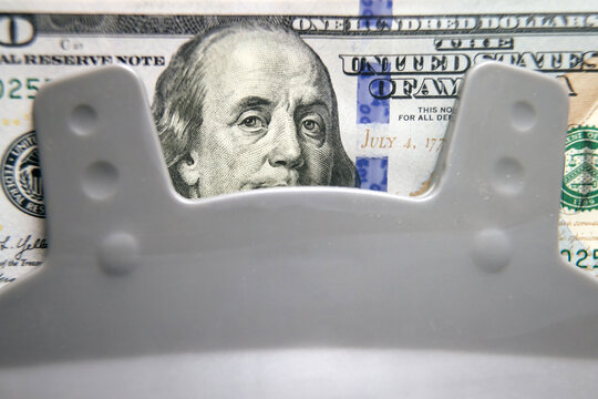 Close-up of dollar bills in an electronic money counting machine, ideal for illustrating financial services, cash management, or currency exchange.