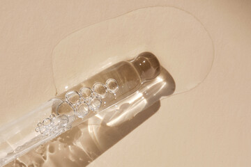 Naklejka premium Pipette with serum on a beige background.