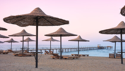 Photo of an empty beach at a purple sunset.