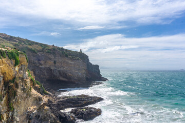 A stunning lighthouse perched on the dramatic cliffs of Otago's coast, New Zealand. Overlooking the Pacific Ocean, this spot offers breathtaking views, perfect for summer outings, birdwatching