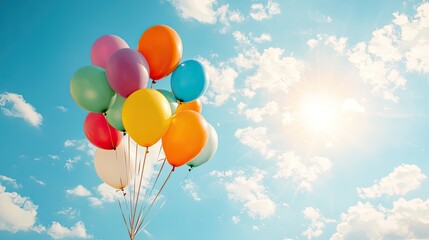 A vibrant group of colorful balloons floating against a bright blue sky, symbolizing joy and celebration.