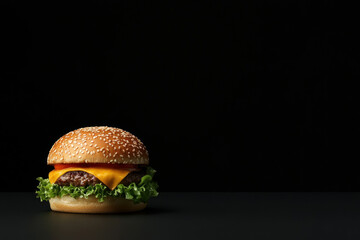 Single hamburger with lettuce, cheese, and sesame bun on a dark background, ideal for food advertising or restaurant menus.