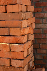 Pile of a bricks against brick wall	