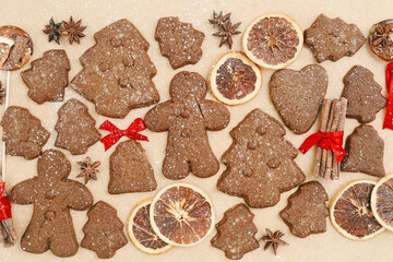 Christmas gingerbread cookies or biscuits on baking paper background. Top view minimal pattern, aesthetic flat lay from homemade festive sweet food, traditional bakery different shapes, new year